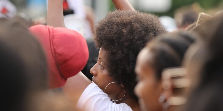 Many black people at a protest, not looking at the camera