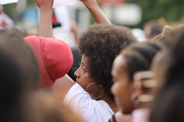 Many black people at a protest, not looking at the camera