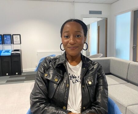 Smiling woman wearing a black leather jacket looking straight at the camera